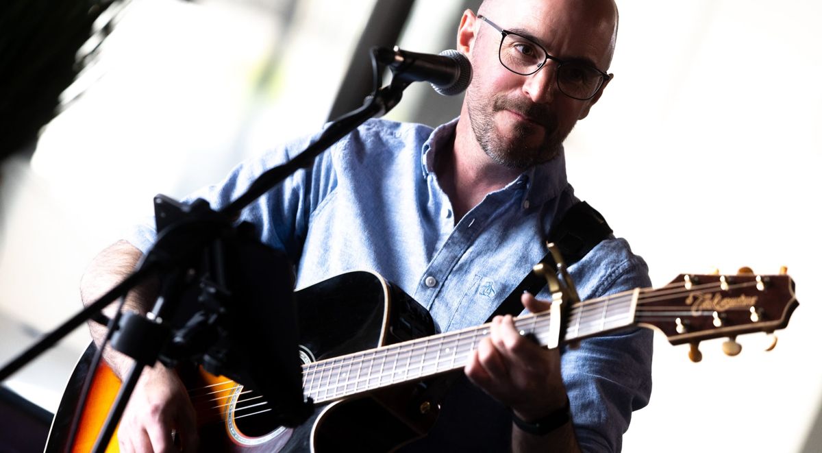 Close-up of Colin playing guitar at the mic